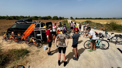Group of cyclists having a snack stop by the HC Bike Tours SAG van during supported ride outside Felantix in Mallorca, Sapin