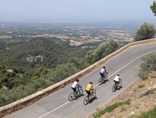 Cyclists climbing Puig de Sant Salvador monastery hill in Mallorca, Spain.