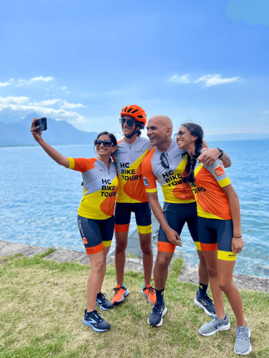 Cyclists taking selfies at photo stop with lake Geneva in the background during a family bike trip from Annecy to Montreux
