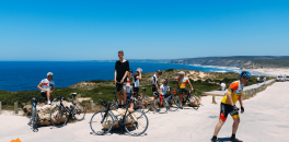 Cyclists posing for a picture with the ocean in the back ground during Portugal bike trip 2016