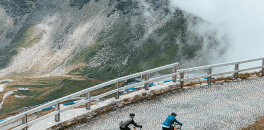 Cyclists riding up Gross Glockner cobbled mountain pass in Austria