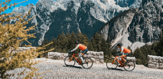 Cyclists riding the cobbled roads of Julian Alps in Slovenia