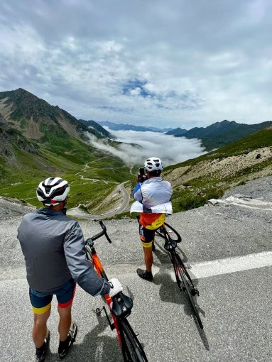 Cyclists enjoying the scenery from the Colm du Tourmalet during French Pyrenees bike trip in July 2023