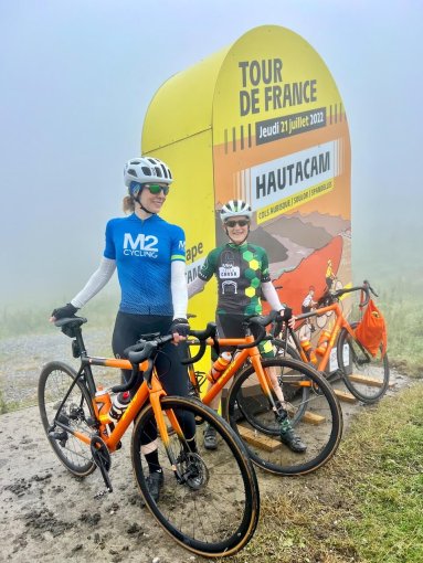 Friends posting for a picture at Hautacam Tour de France landmark during French Pyrenees bike trip in July 2023