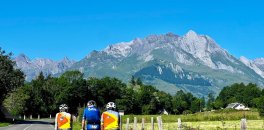 Cyclists riding towards mountains during French Pyrenees bike trip in July 2023