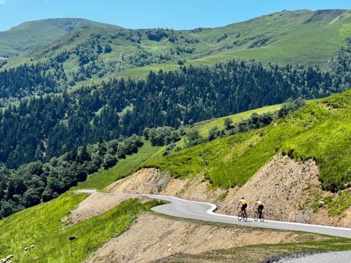 Cyclists descending Port de Bales in French Pyrenees during a bike trip in July 2023