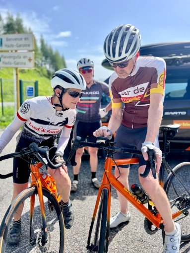 Cyclists checking their navigation equipment during French Pyrenees bike trip in July 2023