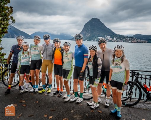 Group of friends posing for a picture with Lake Lugano in the background, during Lake Como bike trip in Italy