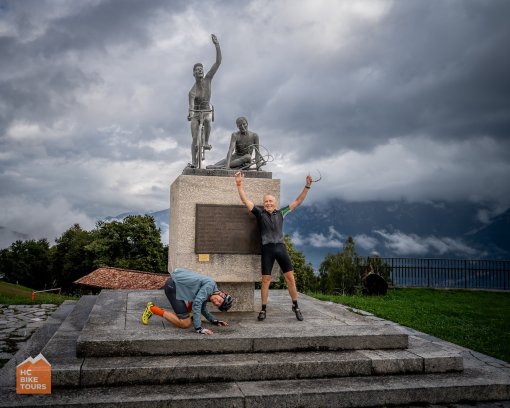 Cyclists posing for a photo at cycling monument at the Madonna del Ghisalo on Lake Como, Italy