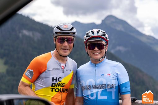 Aigars Paegle, the guide, and a cycling guest smiling in a candid photo taken from the car.