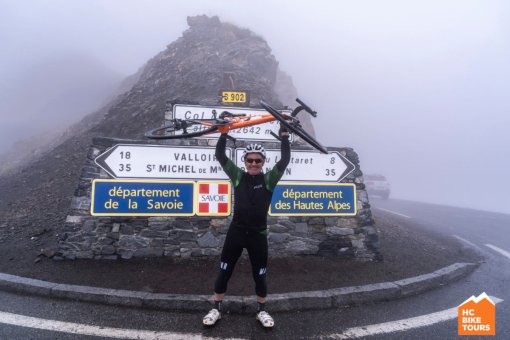 One of our super happy cyclist posing in front of the sign of Col du Galibier